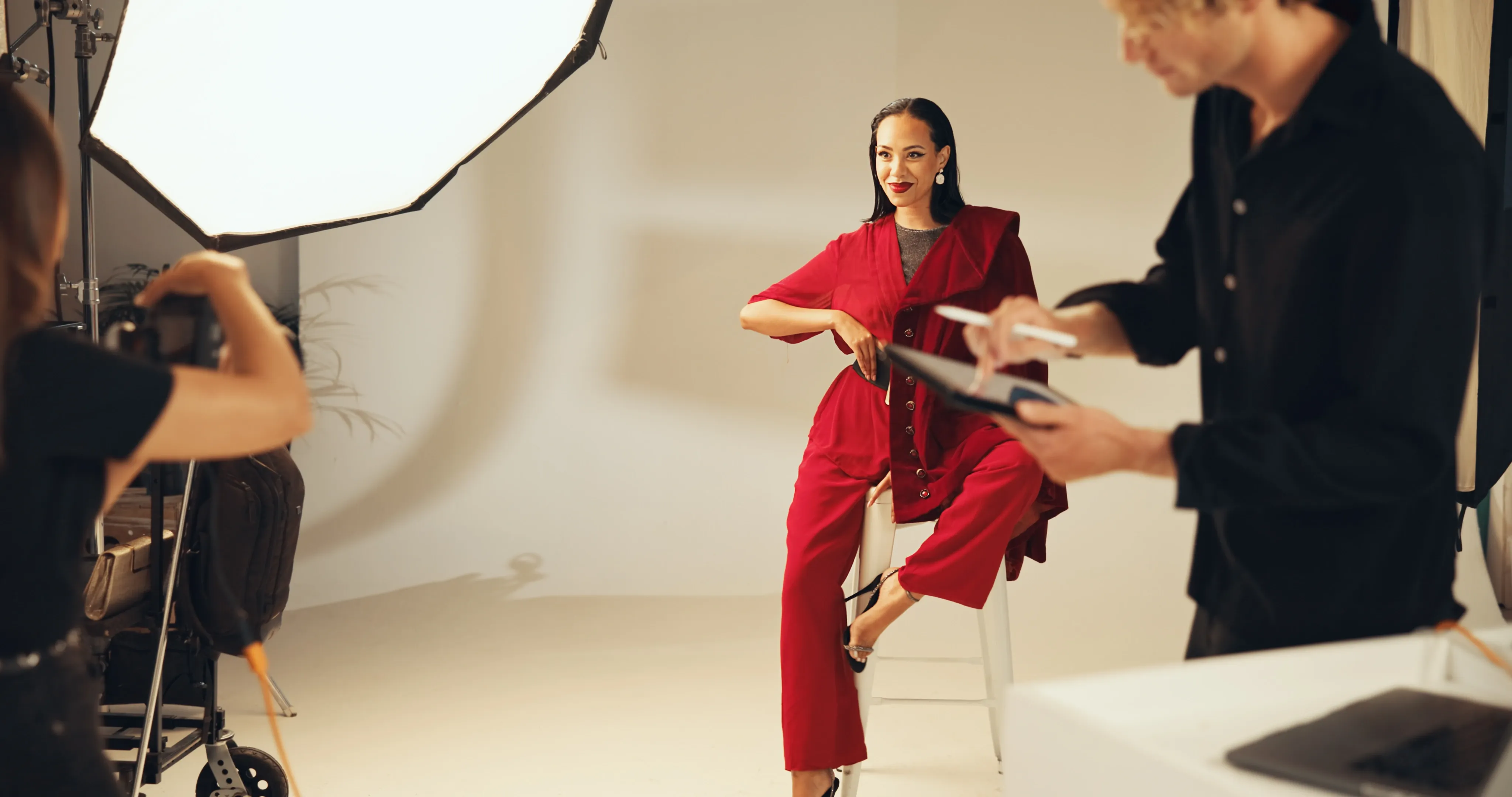 A model on set for a studio shoot, photographed by a crew working from a shot list
